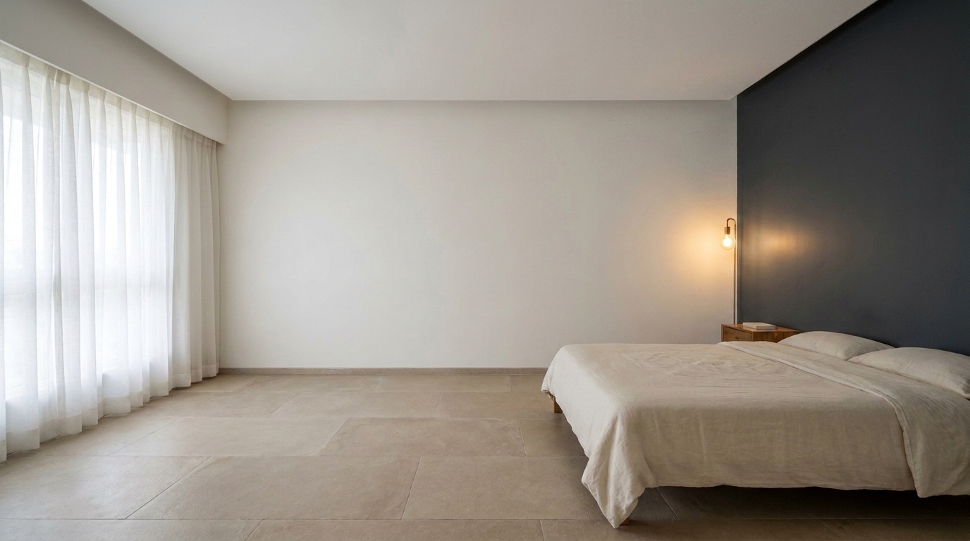 Bedroom with one dark accent wall behind the bed, rest of room in white.