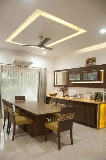 Dining room with a square cove-lit ceiling design, a dark wood dining table with yellow-cushioned chairs