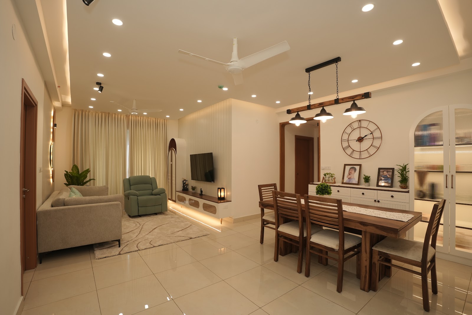 Open-plan living and dining room with a fluted TV feature wall, a three-pendant light over the wood dining table
