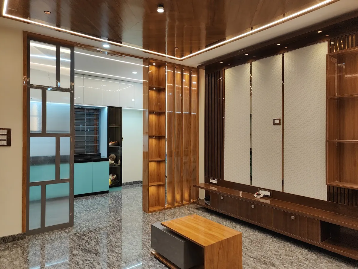 Living room with a glossy wood-clad cove-lit ceiling, a fluted wood display partition, a TV unit wall with textured wallpaper panels, and a wood coffee table
