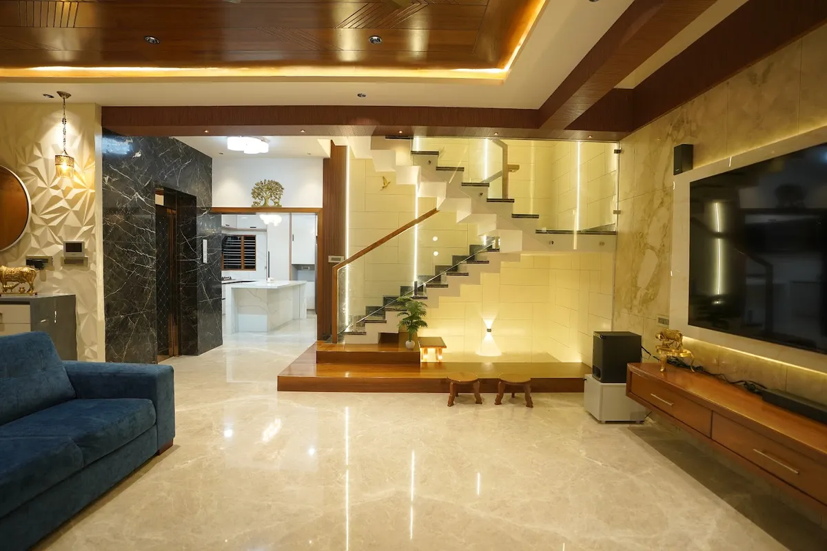 Double-height villa living room with a teak-slat ceiling over cove light, a beige marble TV wall with teak console