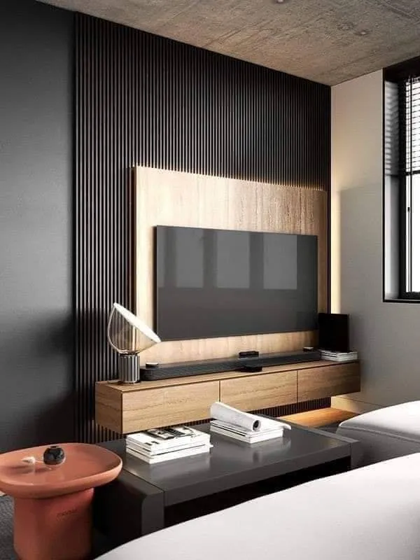 Render of a living-room TV wall in tightly pitched black fluted slats with a backlit oak veneer inset, a floating oak console