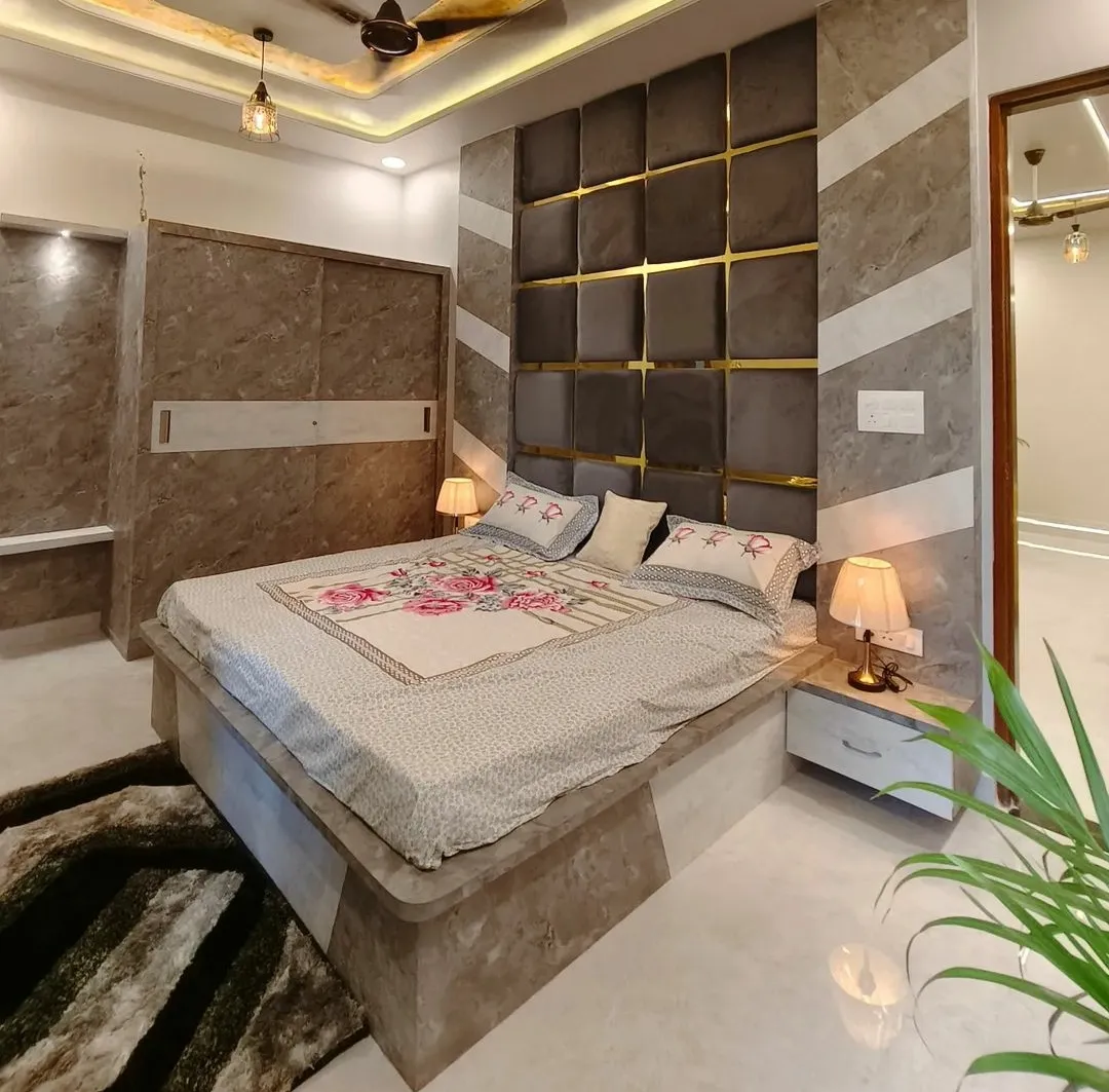 Bedroom with a sixteen-square grid of taupe upholstered panels divided by gold profiles behind the bed