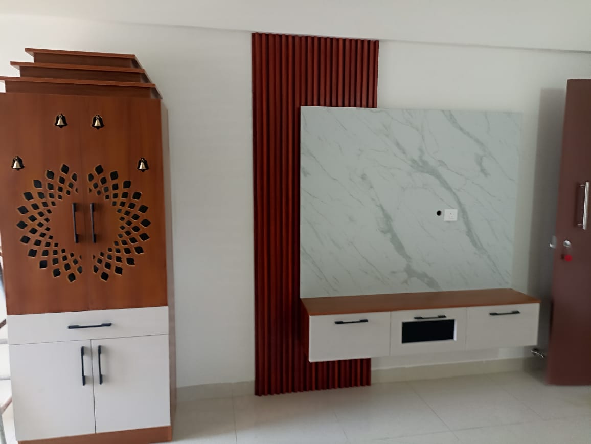 Living-room feature wall with a floating TV console under marble-effect cladding beside a red fluted panel strip