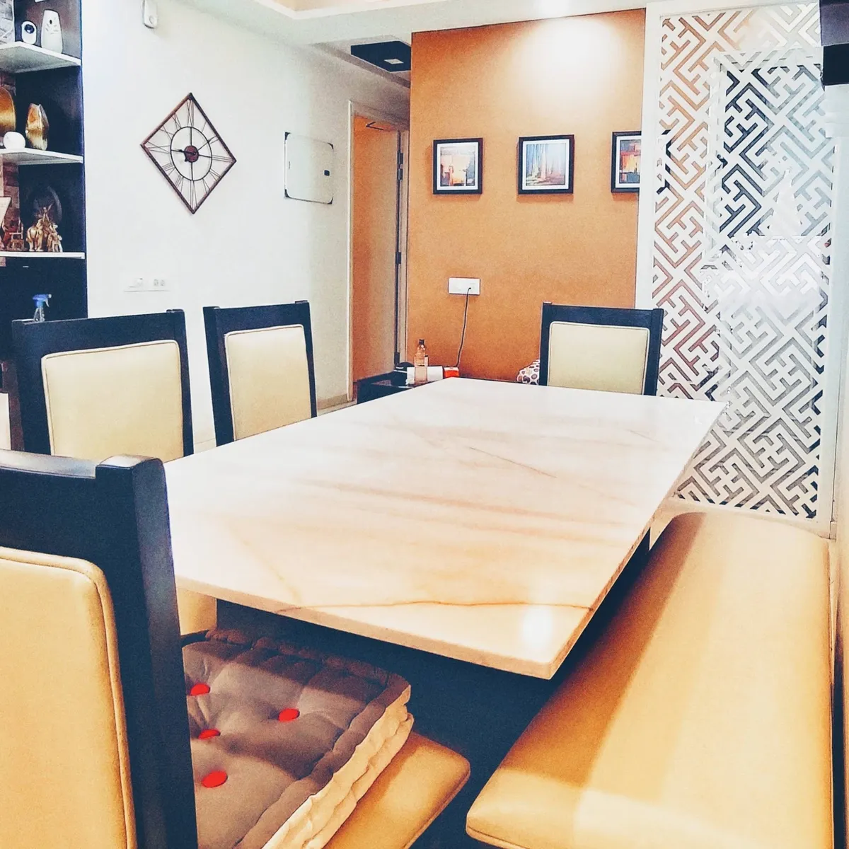 Six-seater dining set with a cream onyx-veined stone top, black-framed leather chairs and a matching bench