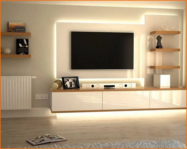 Living room TV wall with a floating white gloss console, warm LED backlighting, and open wood corner shelving.