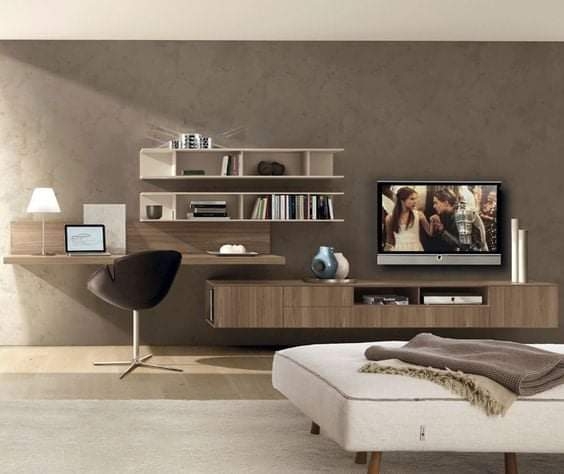 Render of a living room with a floating wood TV wall unit combining open shelving with a built-in study desk, and a cushioned ottoman bench.