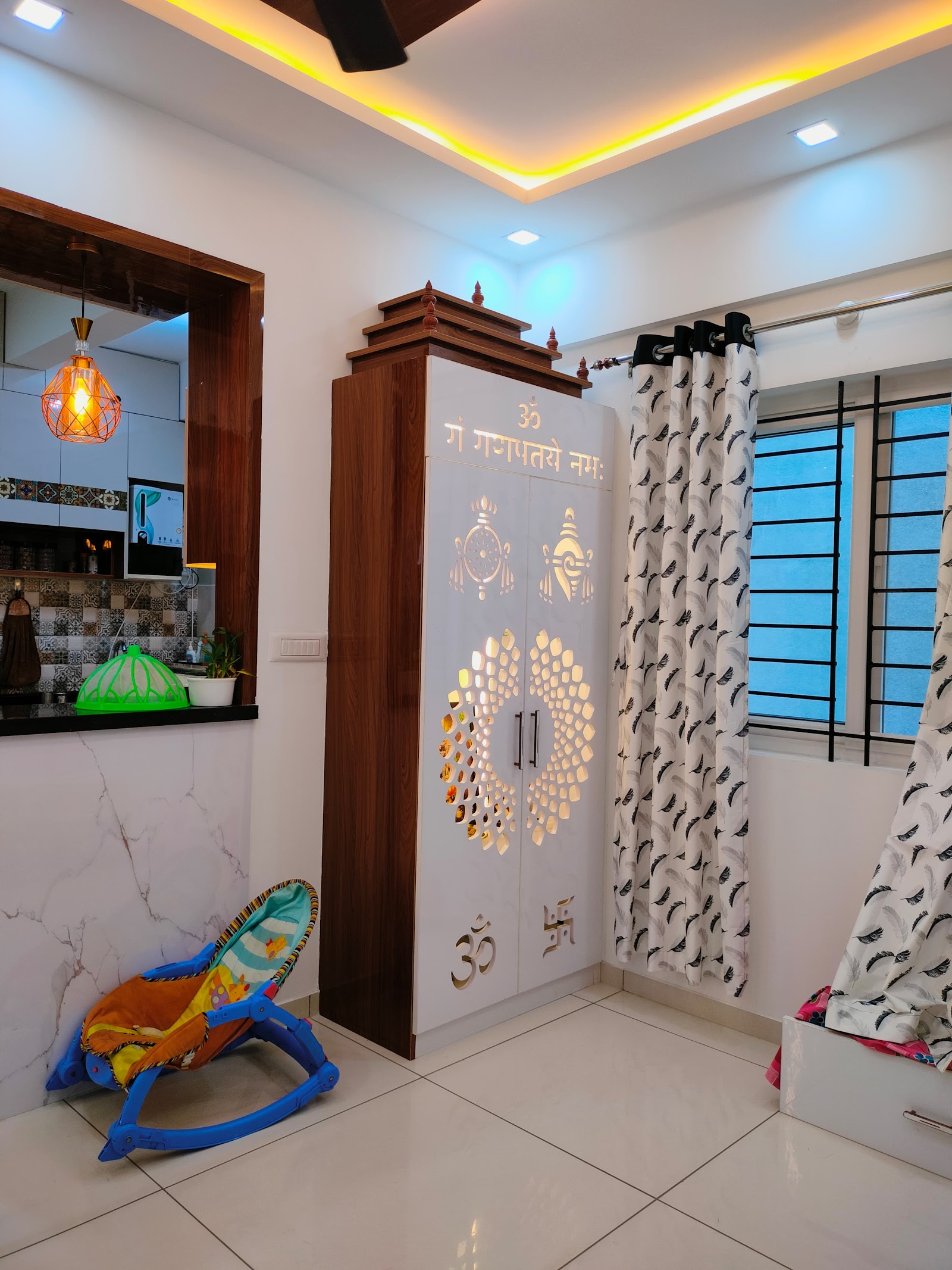 Standalone white and wood pooja cabinet with a temple-style pediment top and backlit jaali-cut doors inscribed with 'Om Gan Ganapataye Namah'