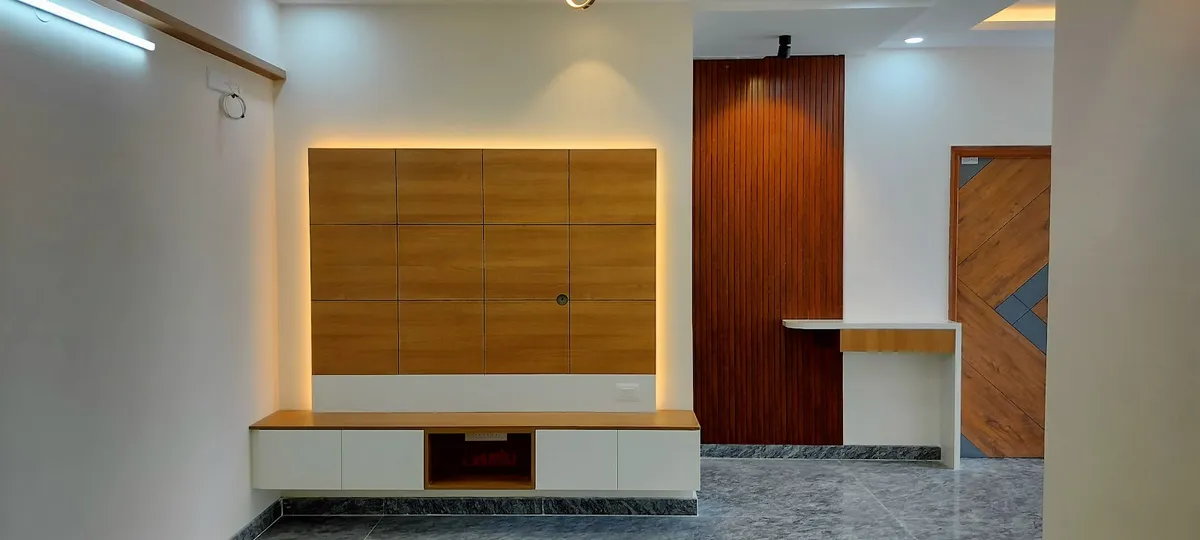 Entrance passage with a backlit wood-panel feature wall over a floating console, a wood-slat clad column and a patterned wood-and-glass main door beyond