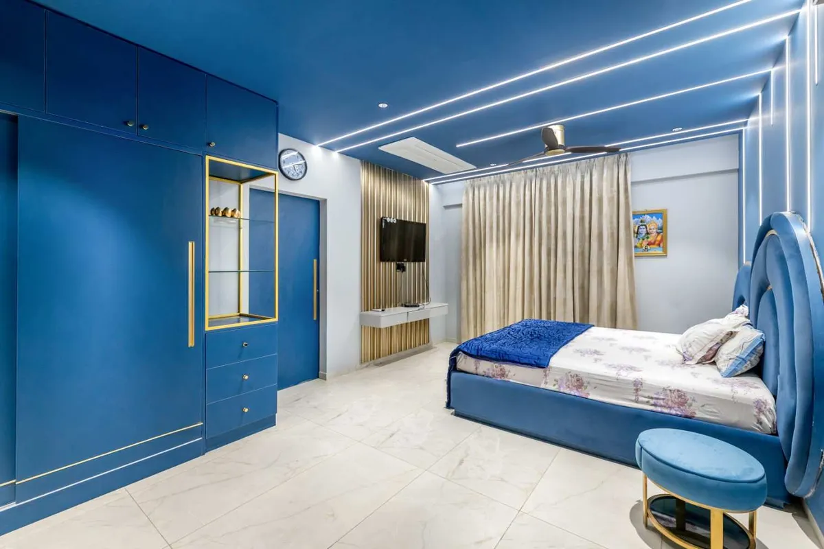 Bedroom done almost entirely in petrol blue - lacquered wardrobe wall with gold inlay grooves and a brass display box