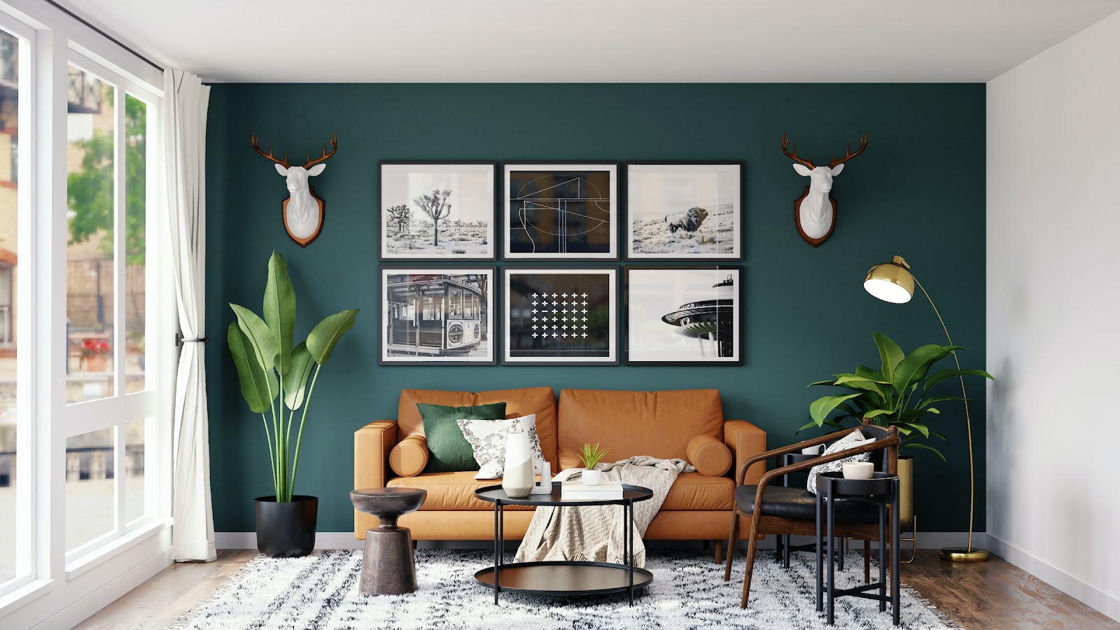 Living room styled in mid-century modern furniture, with a tan leather sofa and walnut-frame armchair against a deep teal accent wall hung with a