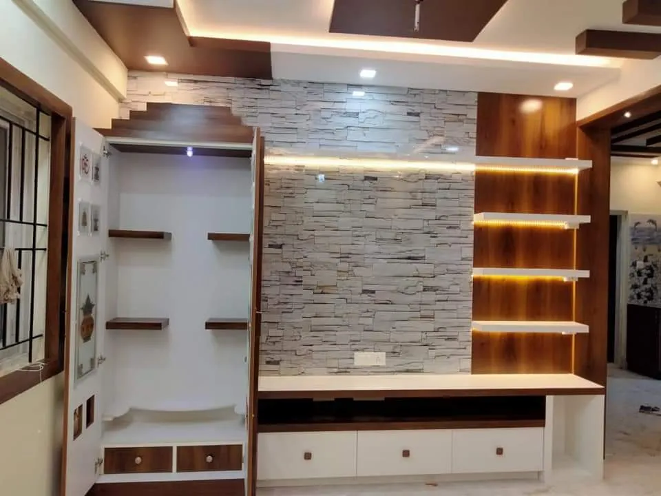 Living-room feature wall at handover: split-stone strip cladding behind a white drawer console