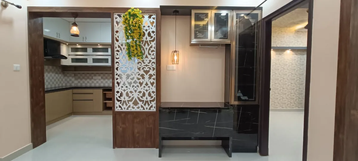 Dining nook with a black marble-topped table and tucked-in bench under a champagne-framed glass crockery unit