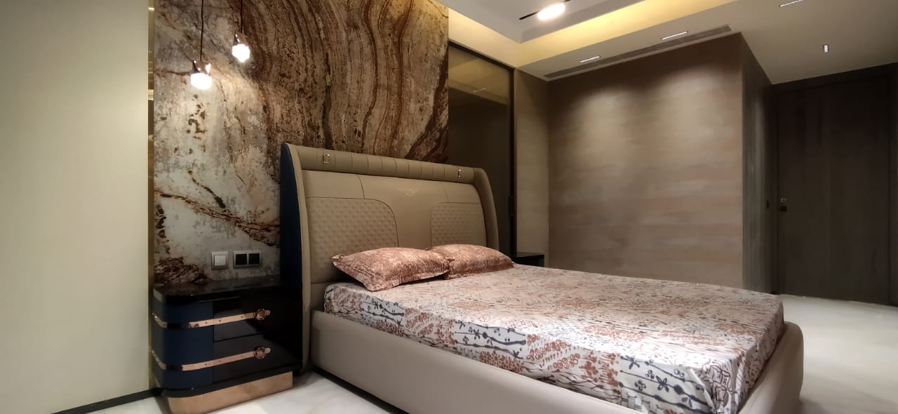 Master bedroom with a dramatic book-matched marble slab feature wall lit by pendant lights