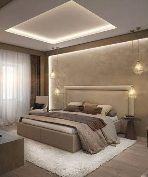 Bedroom with a tall upholstered beige headboard flanked by hanging pendant lights, a backlit textured accent wall