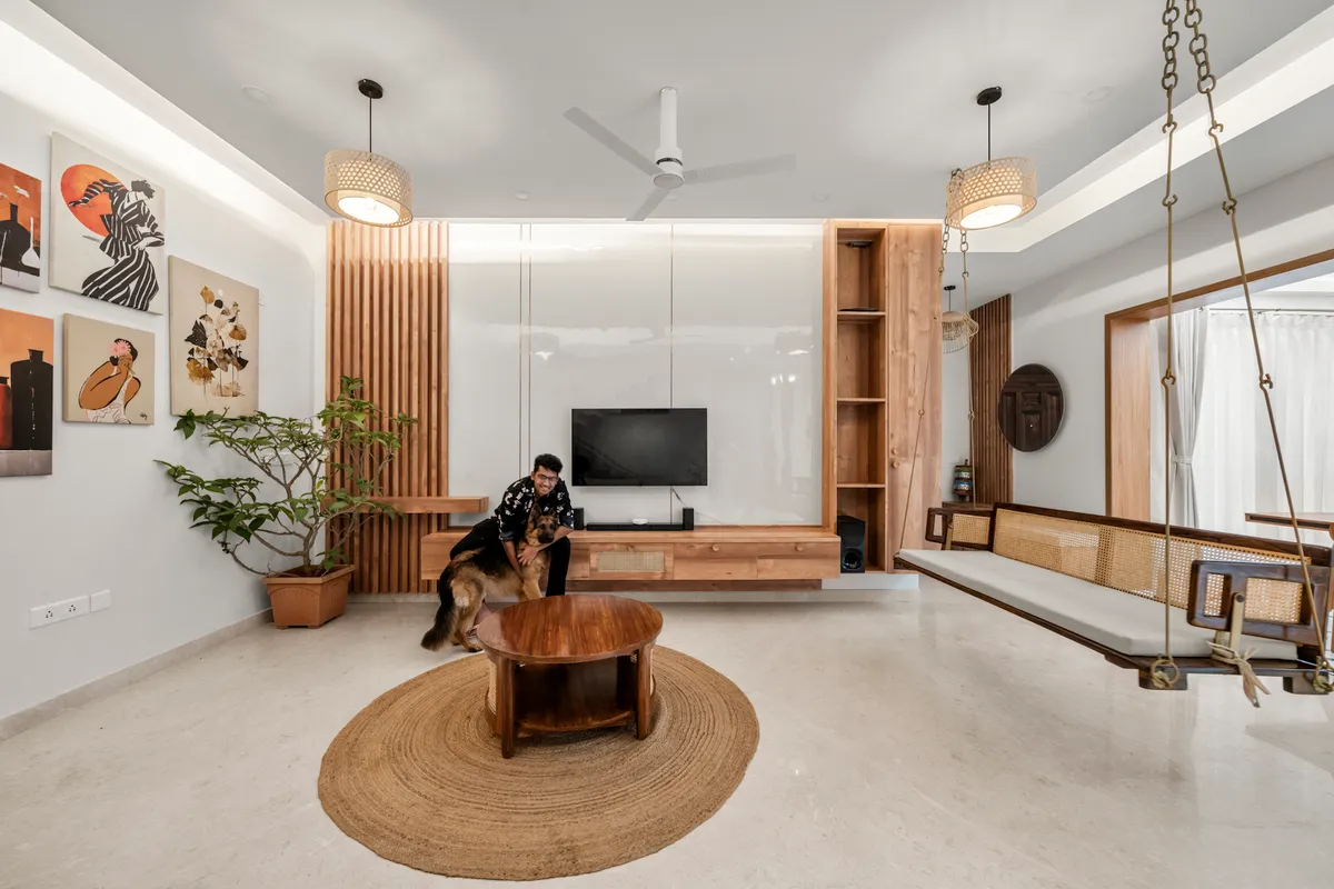Living room with a cane-backed teak jhoola hung on brass chains along the right wall