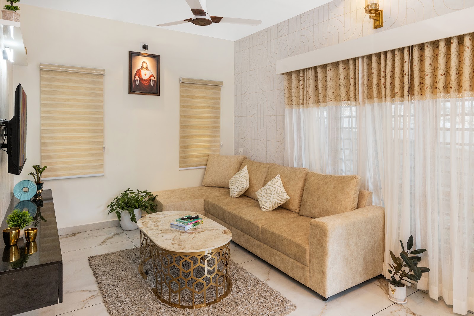 Living room with a beige L-shaped sofa and gold-hexagon marble coffee table, set against a textured geometric-patterned accent wall with a brass sconce