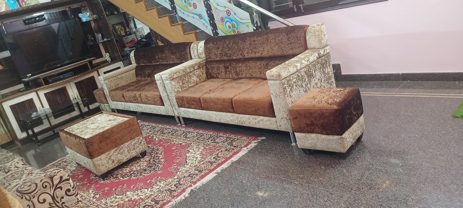 Real living room with a brown and cream crackle-velvet sofa set and matching ottomans on a red oriental-pattern rug