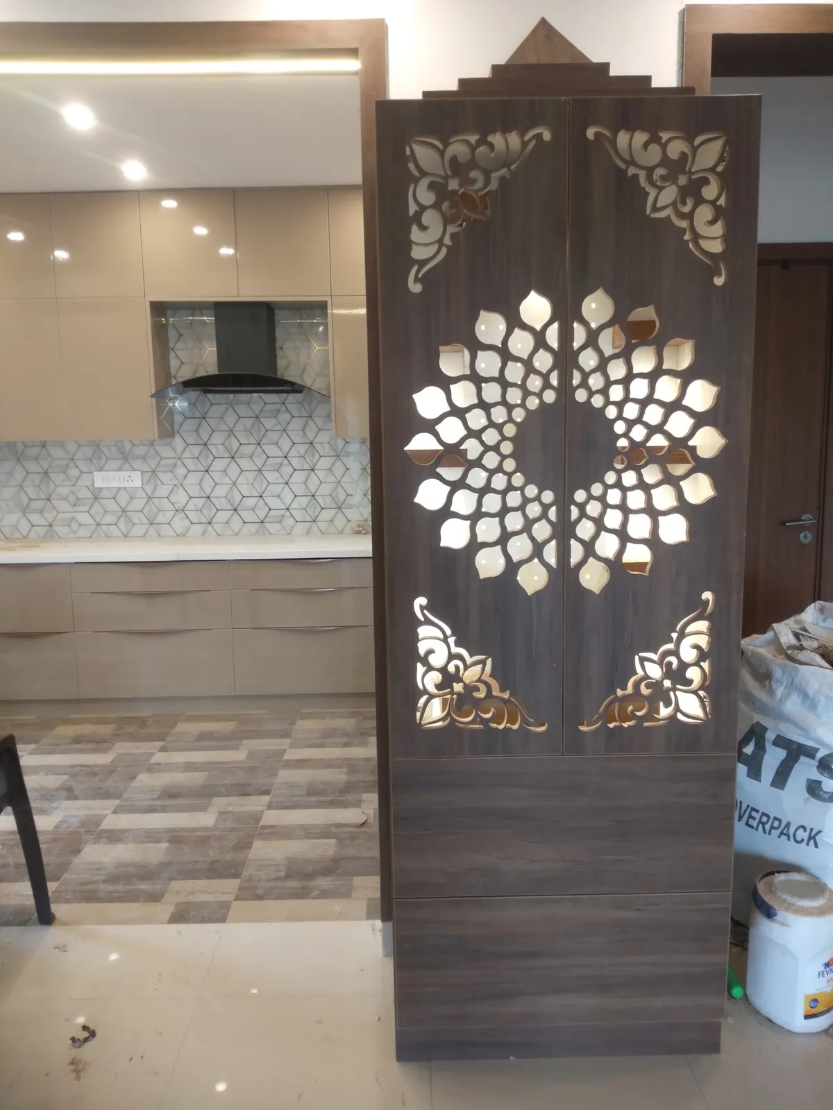 Free-standing pooja mandir cabinet with a temple-style pediment top and backlit lotus-pattern laser-cut wood doors