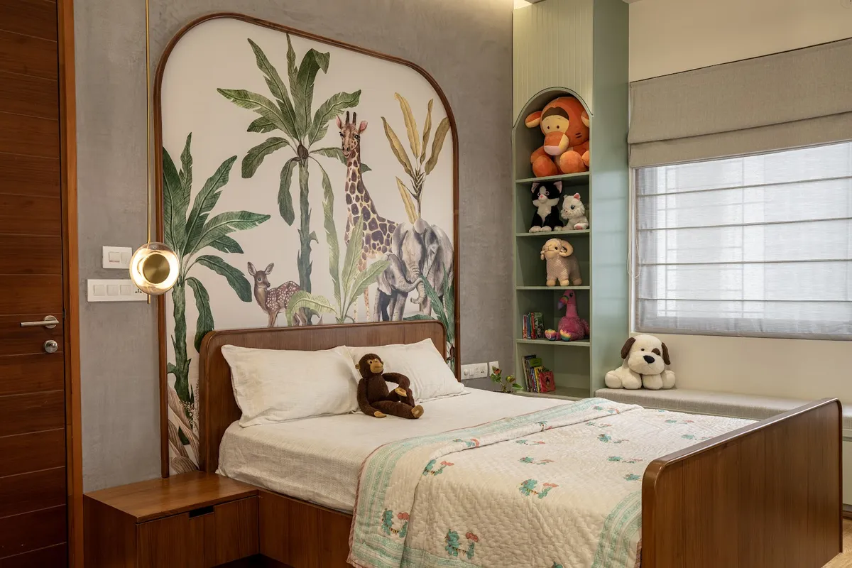 Child's bedroom where a watercolour safari mural of a giraffe, elephant and spotted deer among banana palms sits inside an arched teak frame behind a curved