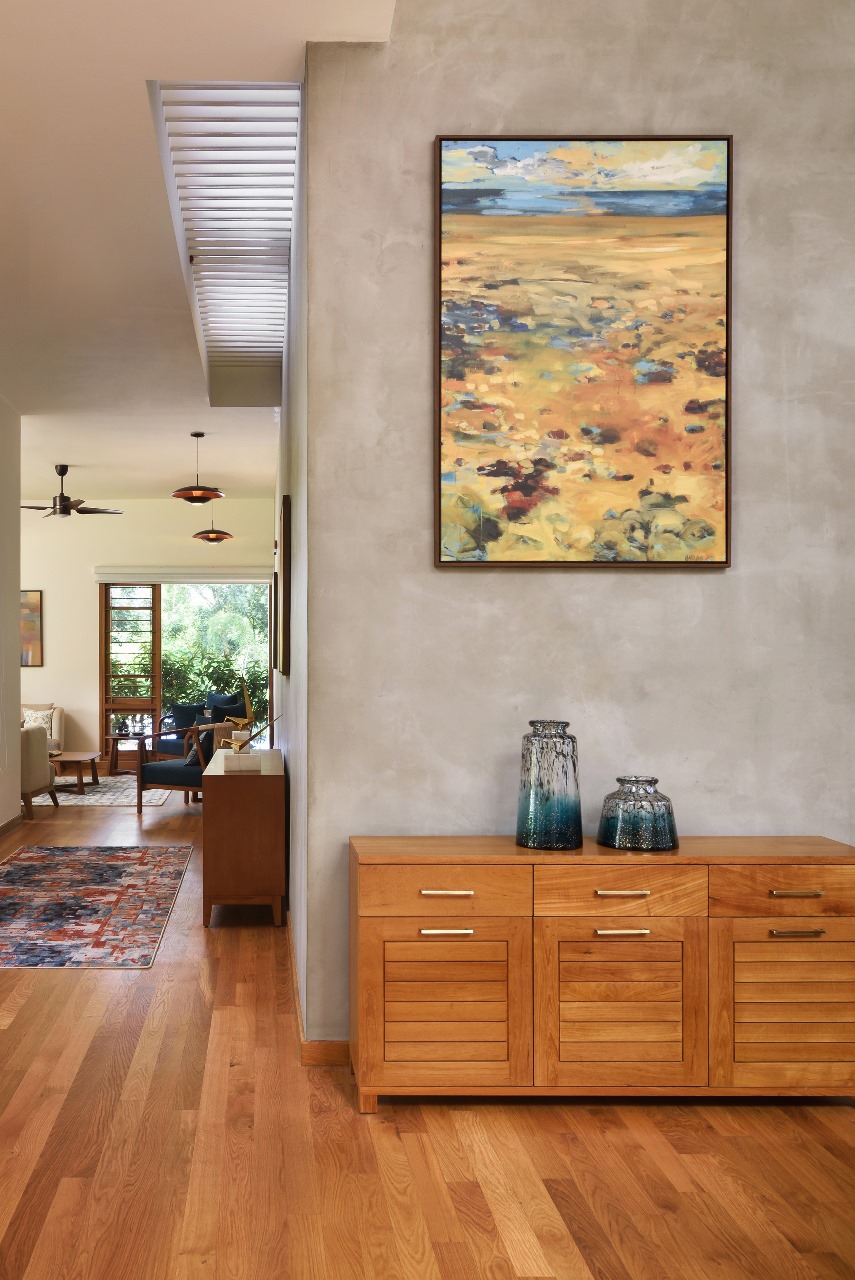 Real photo of a mid-century style entrance hallway with a wood credenza topped with ceramic vases