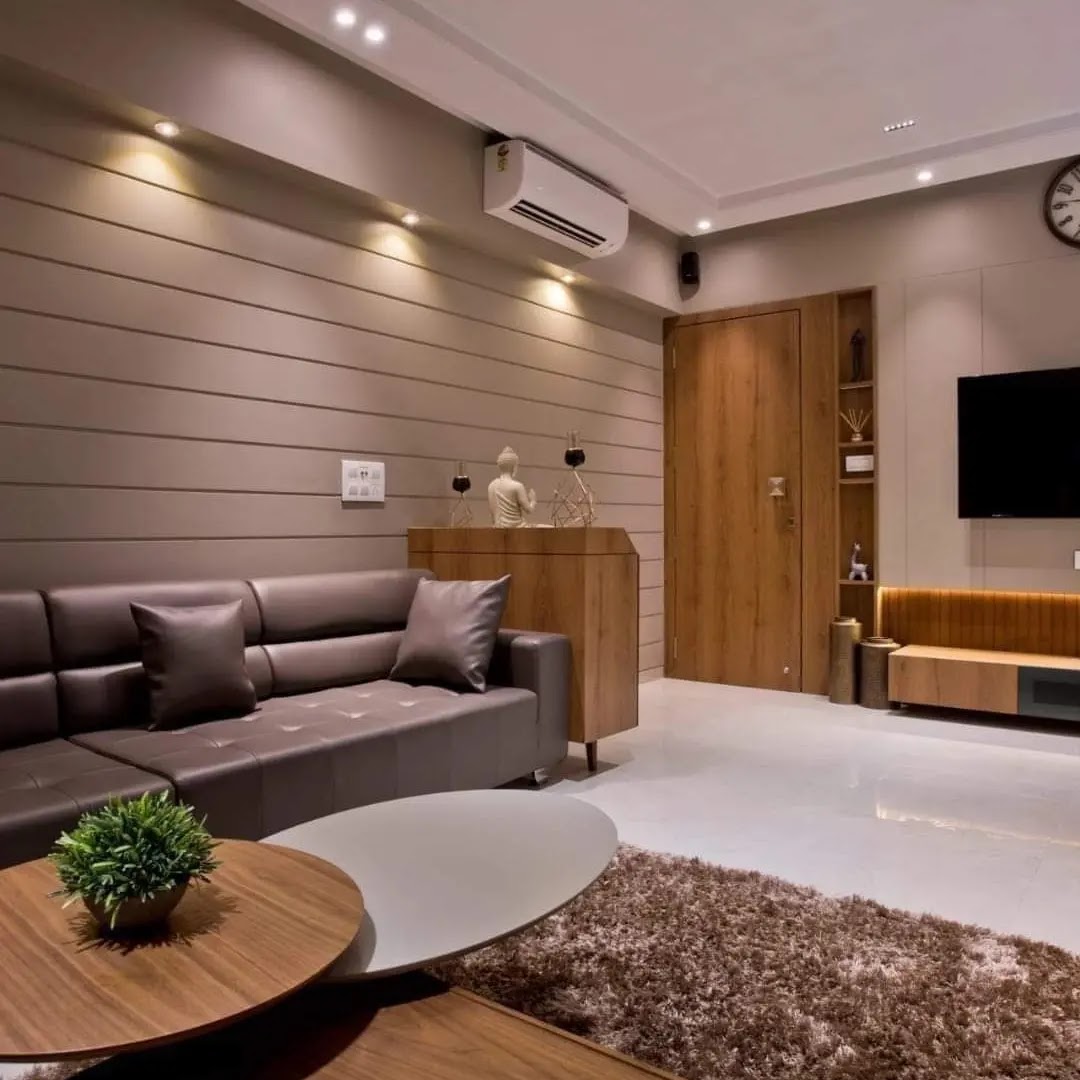 Living room with a horizontal slat-panelled feature wall, a brown tufted leather sectional sofa, round wood-and-white coffee tables on a shag rug