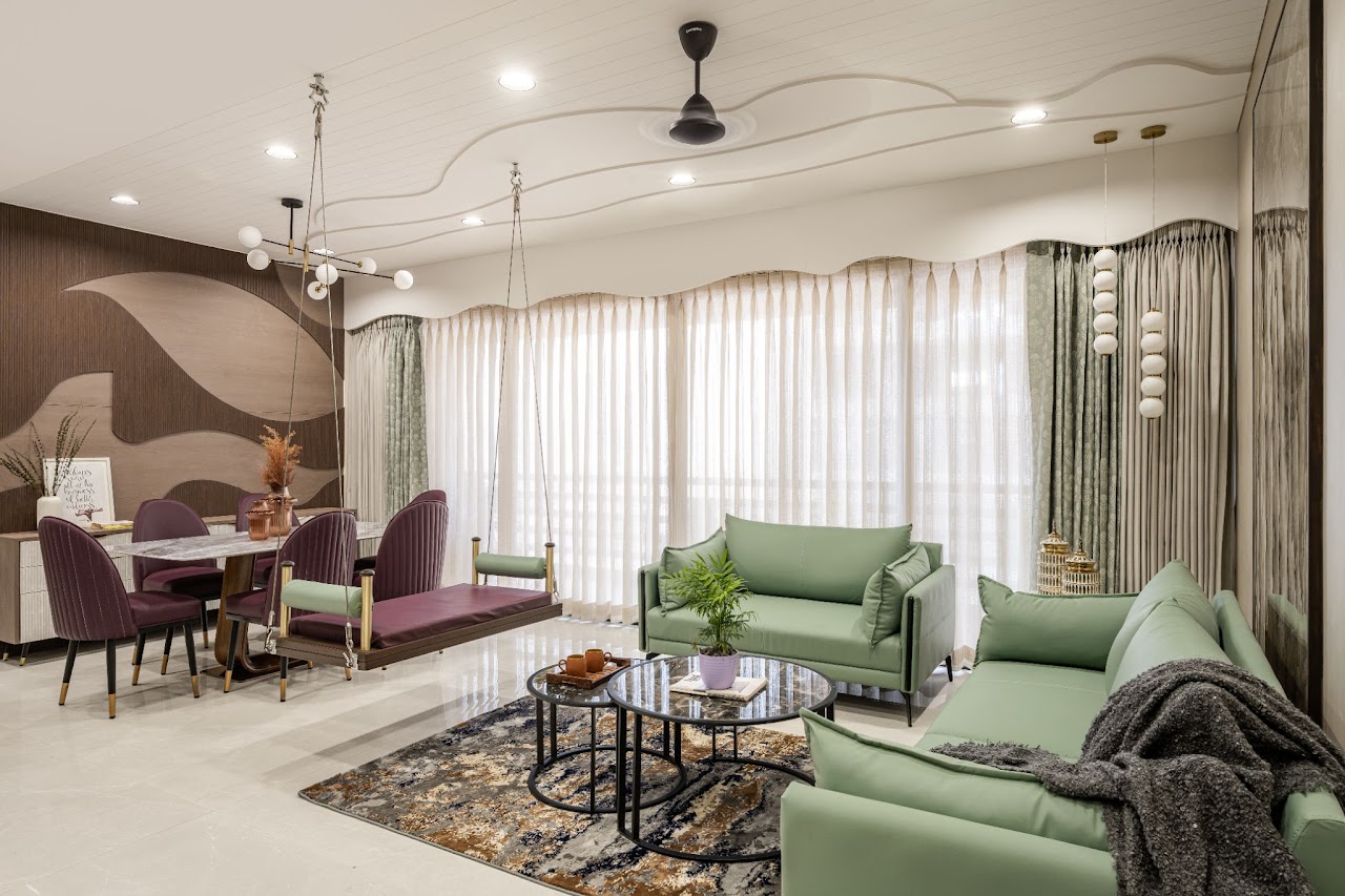 Open-plan dining and living area with a wave-contoured cove ceiling, a burgundy leather hanging swing bridging a purple velvet dining set and sage-green sofas