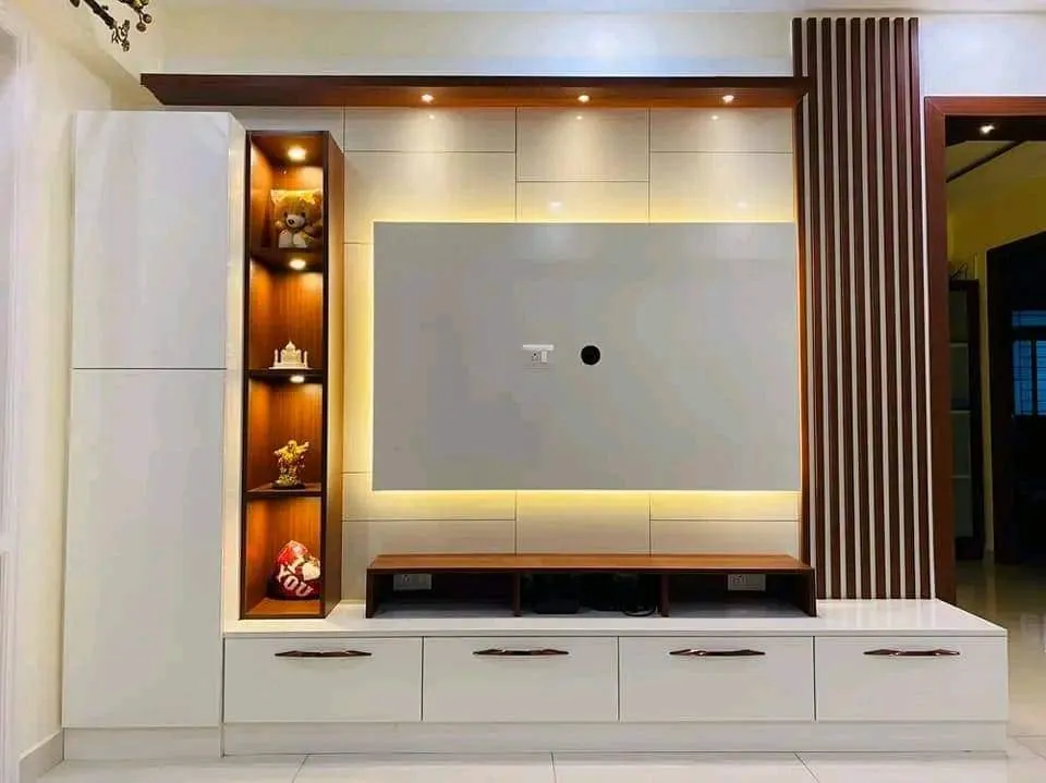 A white gloss TV unit wall with a backlit display niche and a dark fluted-wood slat accent column beside the screen recess.