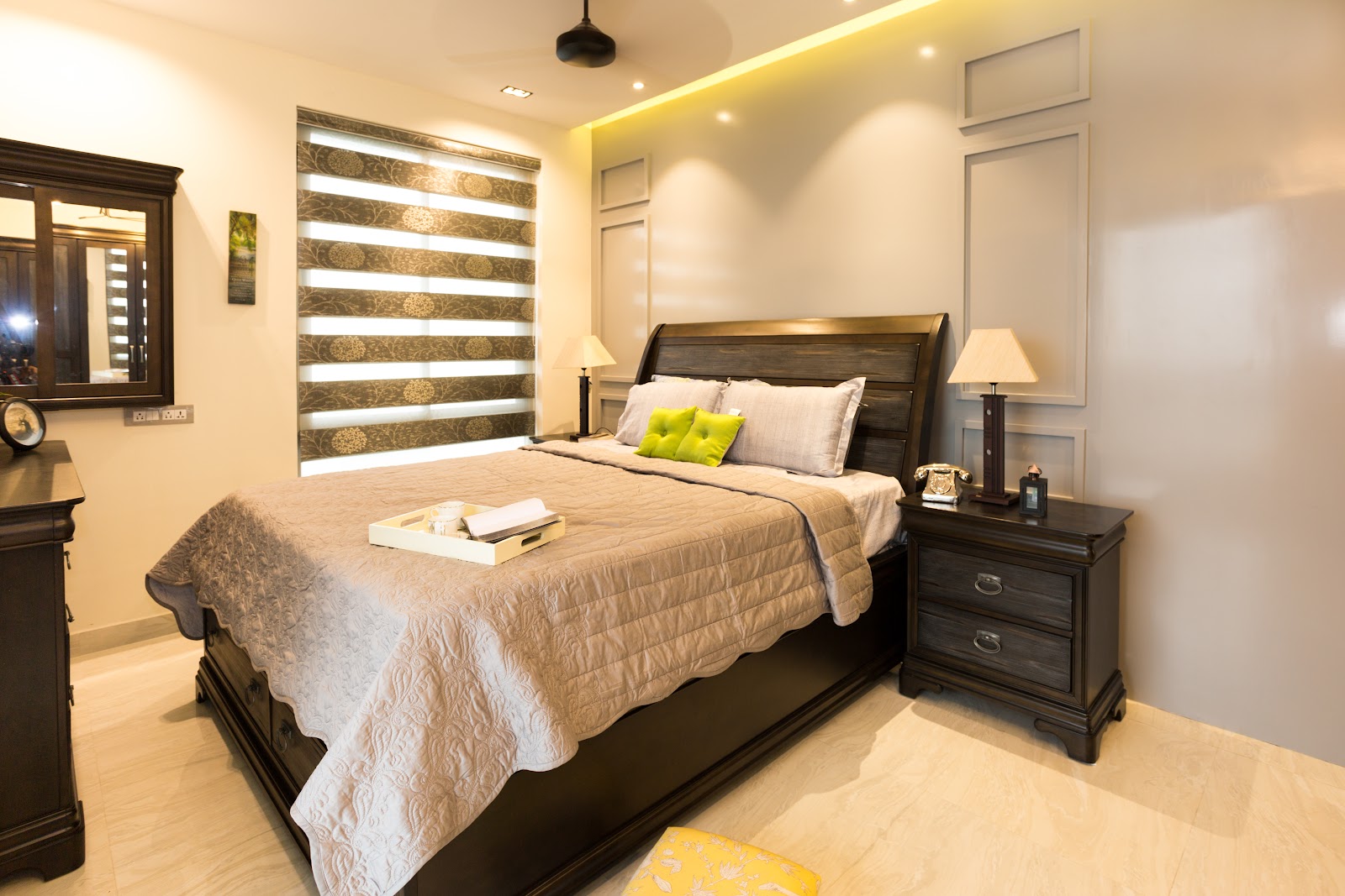 A classic bedroom with a dark wood sleigh bed with footboard storage, matching nightstands with lamps