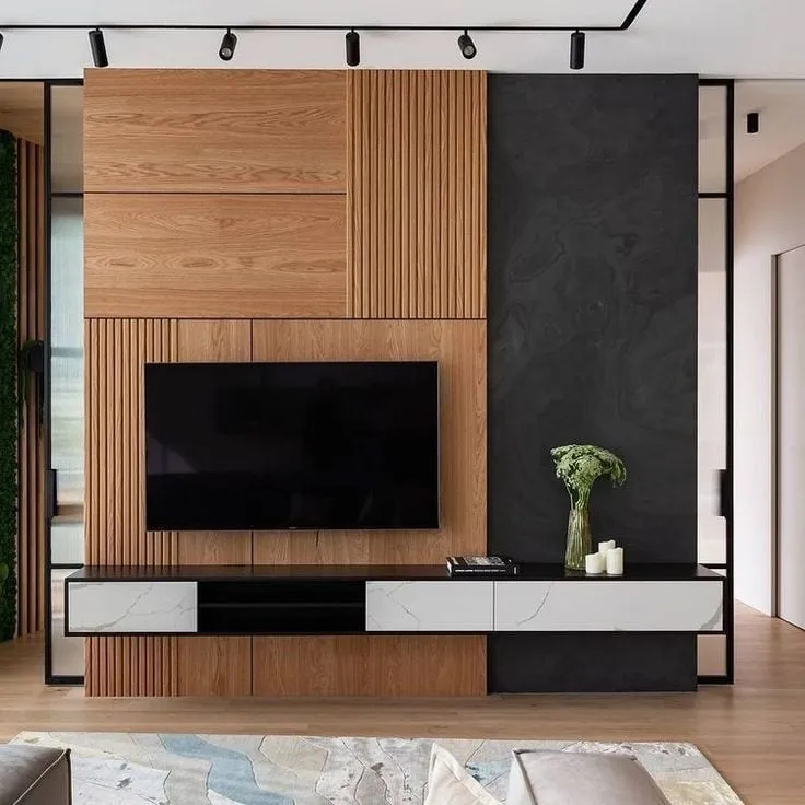 Oak media wall that mixes flat veneer, fine vertical fluting and a charcoal stone slab