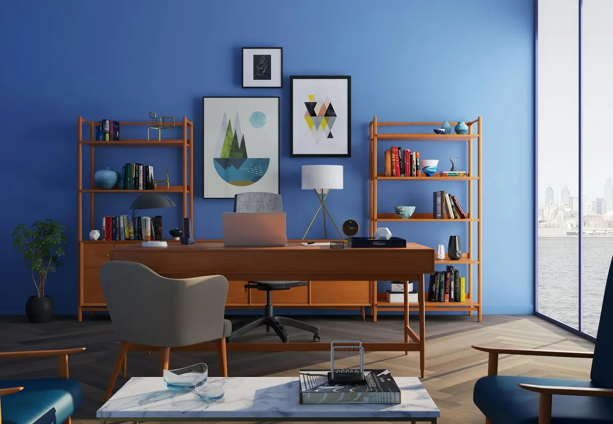 Render of a mid-century style home study with a teak desk flanked by matching open bookshelves against a bold blue accent wall