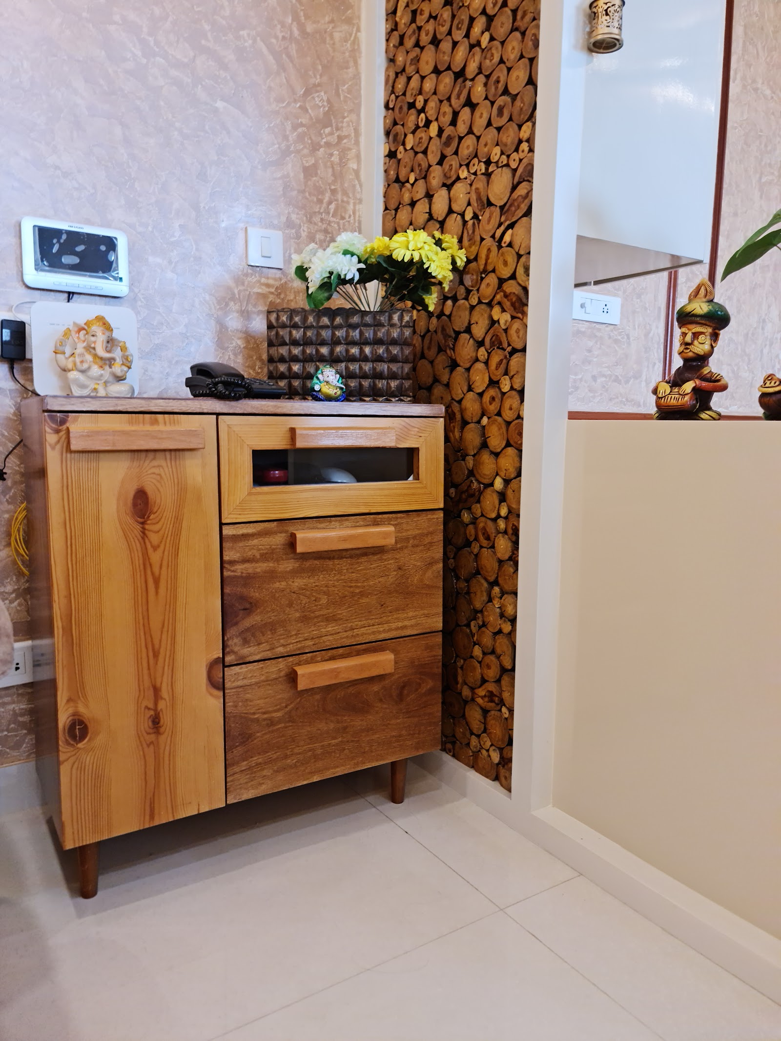 Home entrance foyer with a solid pine wood storage console topped with a video door phone, a Ganesh idol and a flower vase