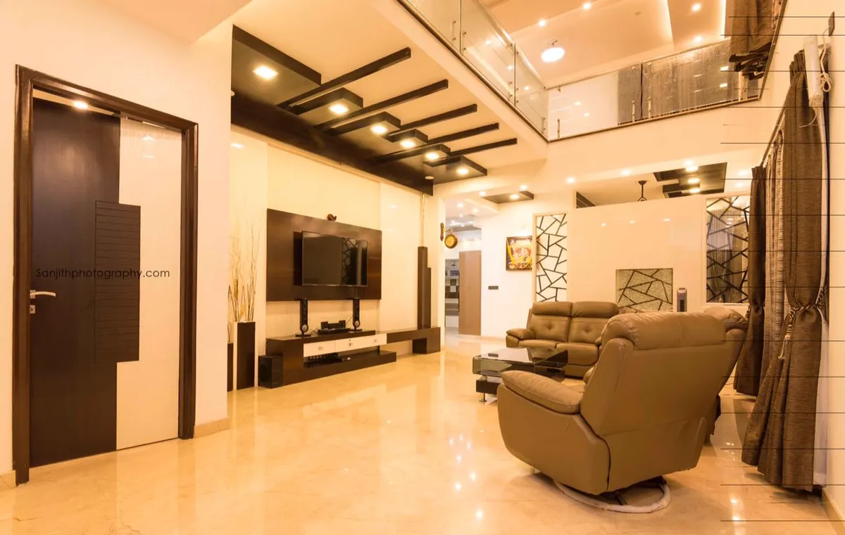 Double-height living room with staggered dark-wood ceiling battens carrying spotlights, a TV on a dark veneer panel