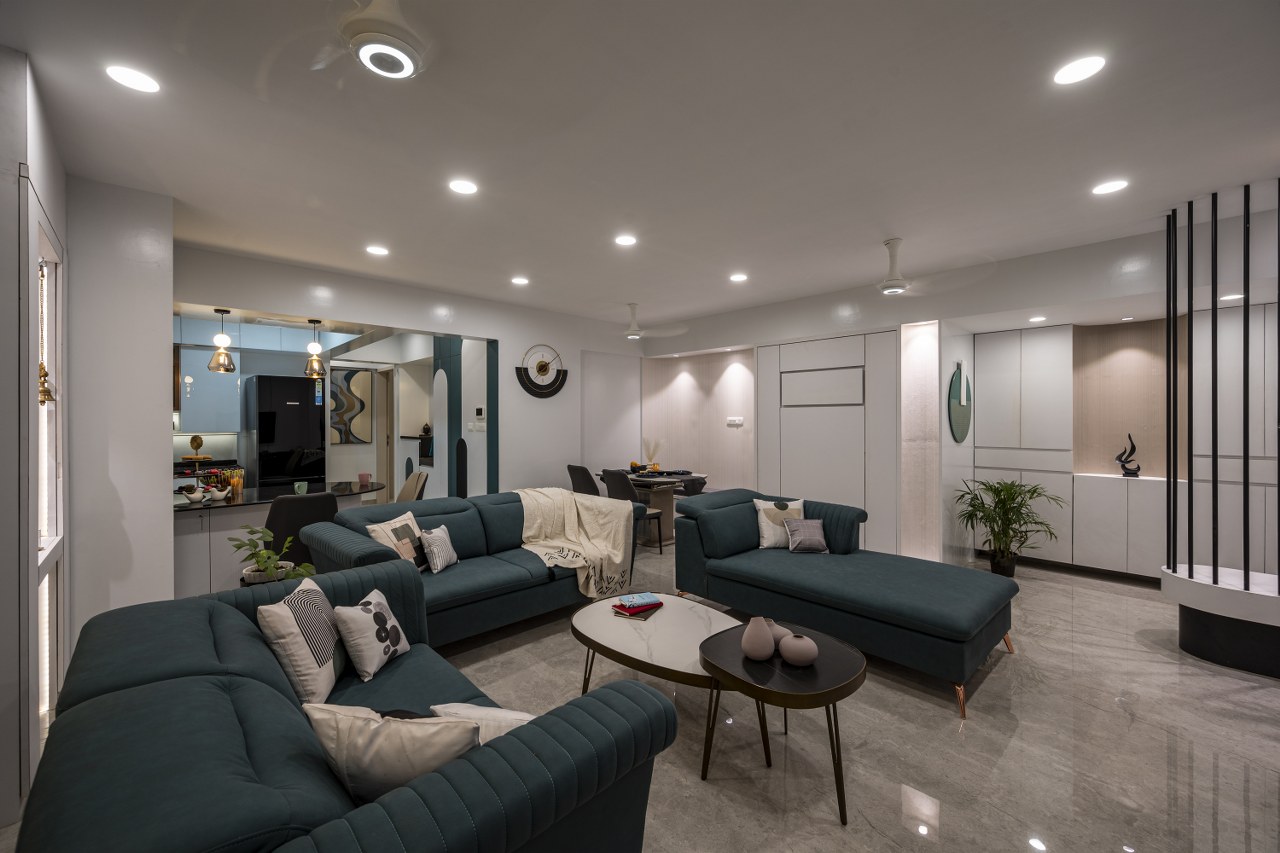 Open-plan living room with a teal channel-tufted velvet sofa set and layered marble-top nesting coffee tables