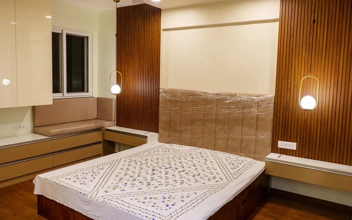 Bedroom photographed at handover with the beige tufted headboard still in its plastic wrap