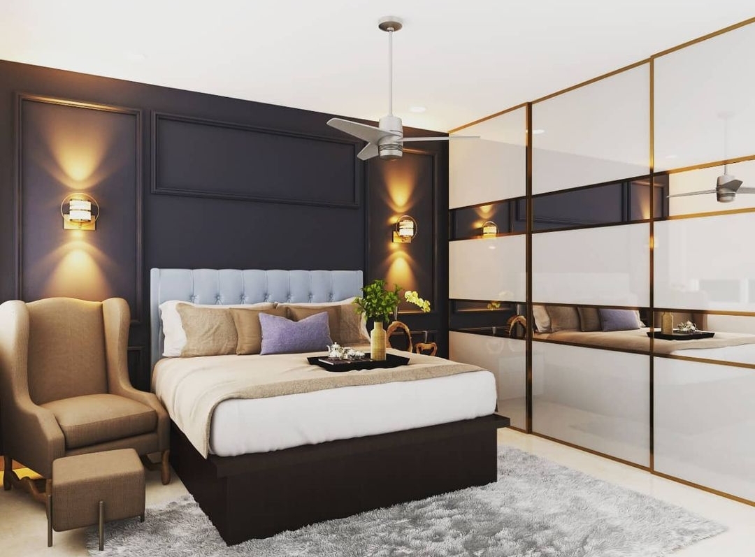 Render of a bedroom with a navy panel-moulded headboard wall, brass wall sconces, a tufted pale-blue headboard, and a mirrored wardrobe with a brass grid frame.