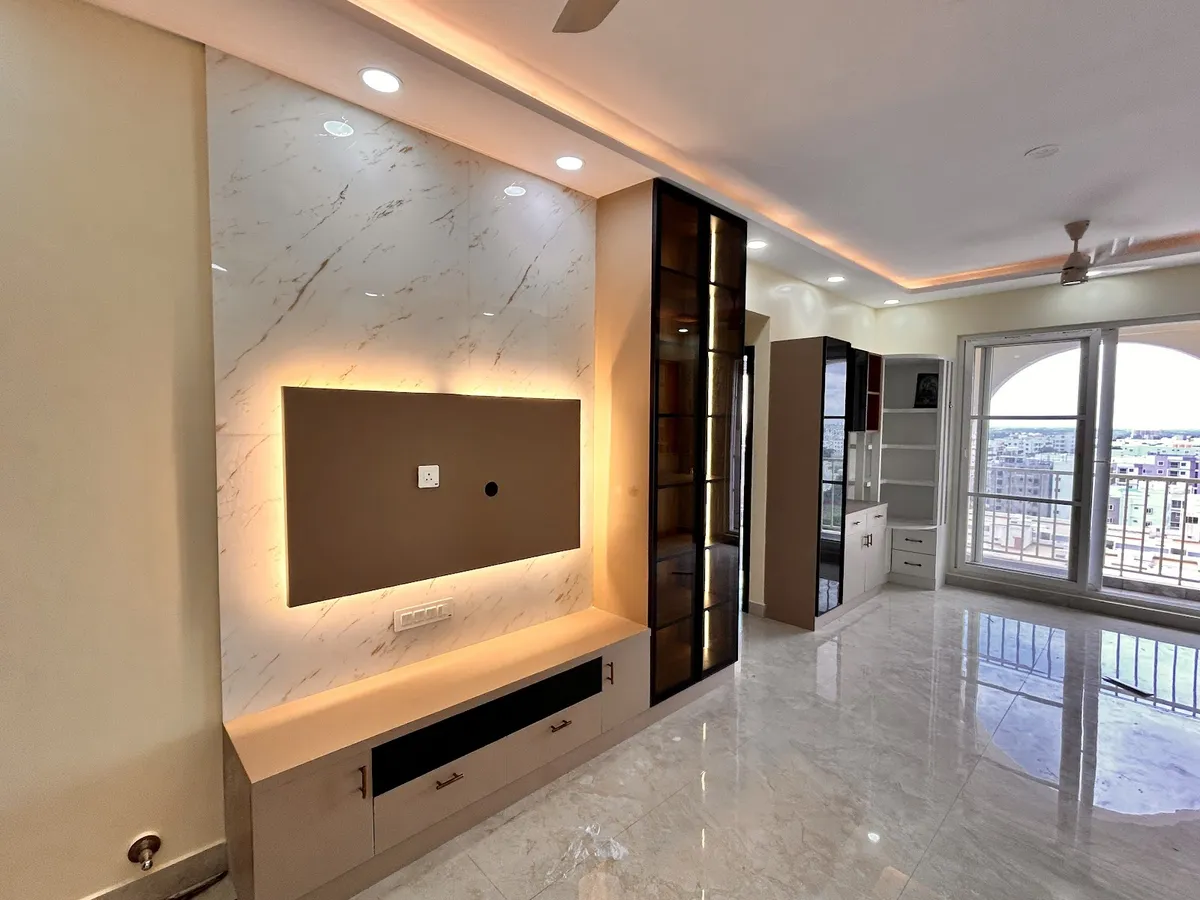 Empty flat living room at handover with a backlit taupe TV panel on a marble-look slab wall over floating drawers