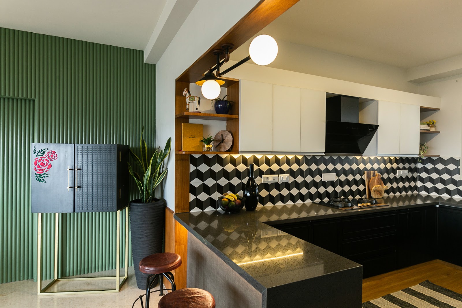 Kitchen with a 3D black-and-white geometric tile backsplash, black lower cabinetry, cream upper cabinets