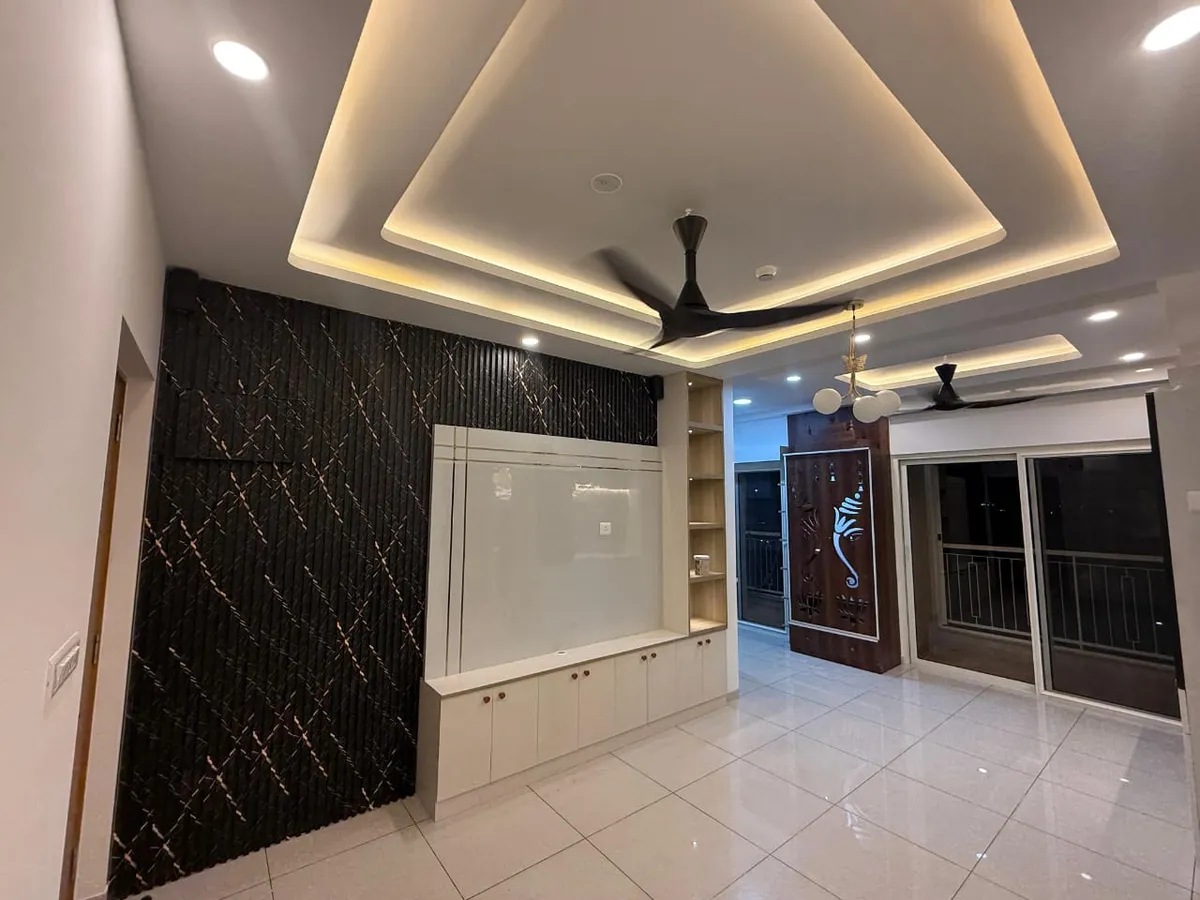 Living room with a fluted dark-textured TV feature wall, a layered cove-lit pop ceiling