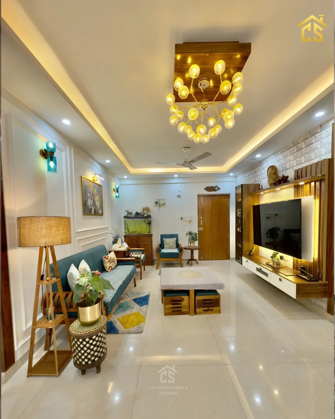 Living room where a brass sputnik cluster of amber glass bulbs drops from a teak ceiling box, over a teal-cushioned teak sofa
