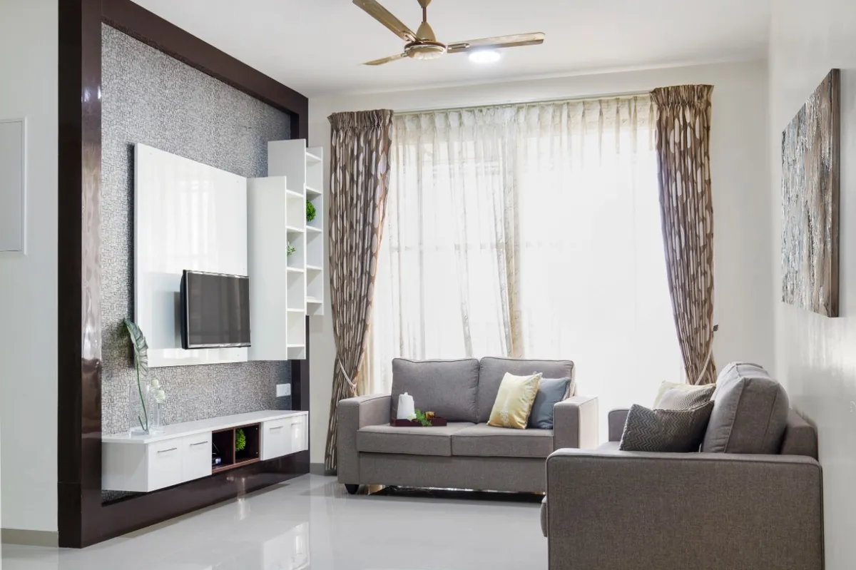 Living room with a grey sofa set, a textured wallpaper TV feature wall with white gloss panelling and floating shelves