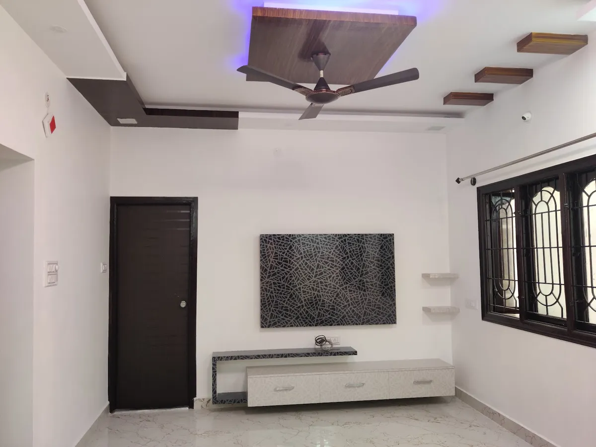 A living room with a black-and-white crackled-pattern TV feature wall, a floating storage console below
