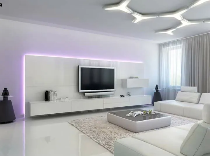 Render of an all-white living room with a purple-backlit TV wall, sculptural branched ceiling light and a white sectional sofa.