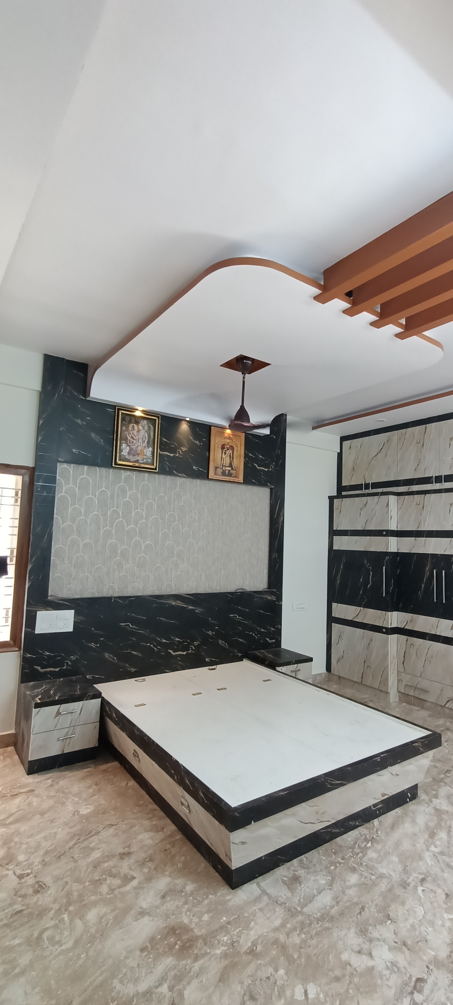 Master bedroom with a black-and-white marble-effect headboard wall featuring a textured arch-pattern insert panel, a matching two-tone marble-finish wardrobe