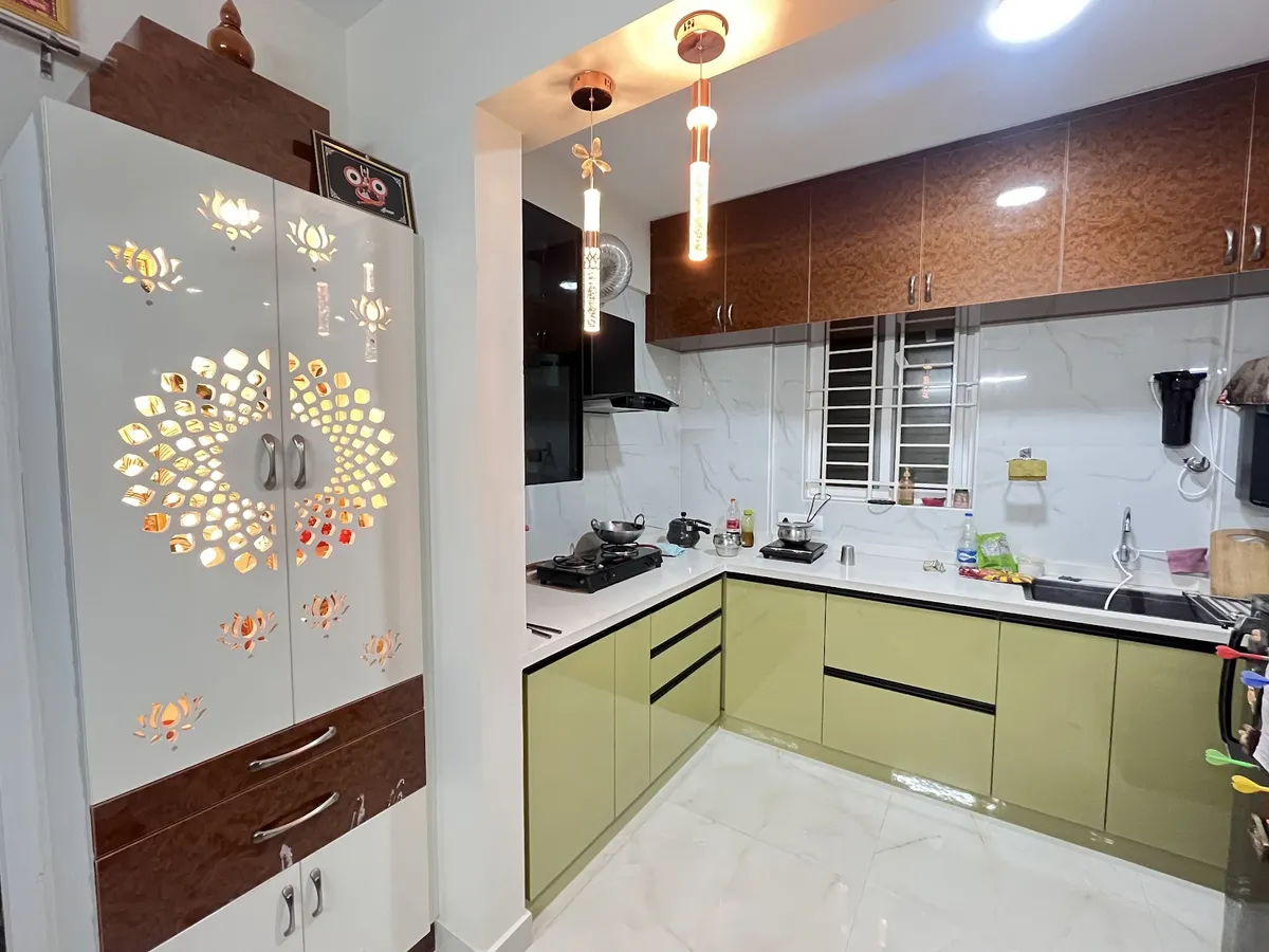 Lived-in wrap-around kitchen in olive high-gloss shutters with burl-pattern overheads and a marble-look dado