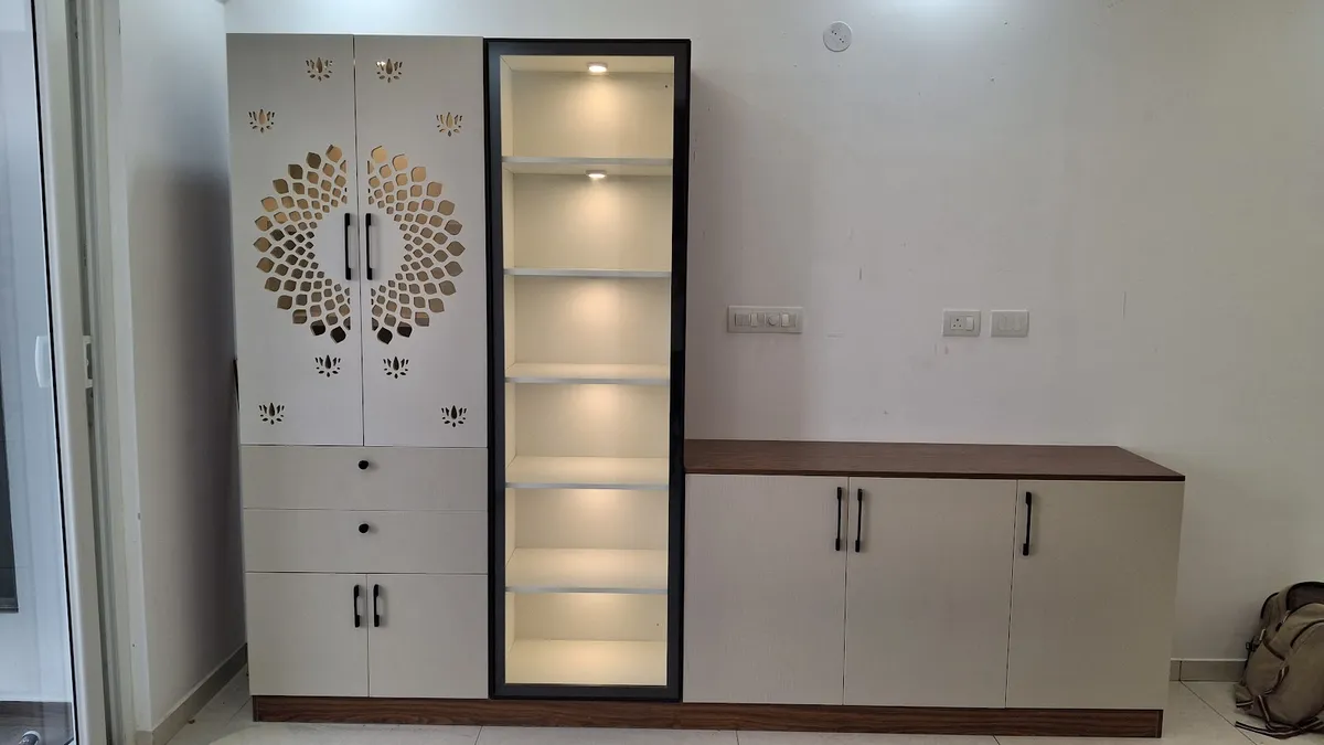Freshly installed mandir unit against a bare wall: CNC lotus-and-sunburst cut shutters over drawers and a base cupboard