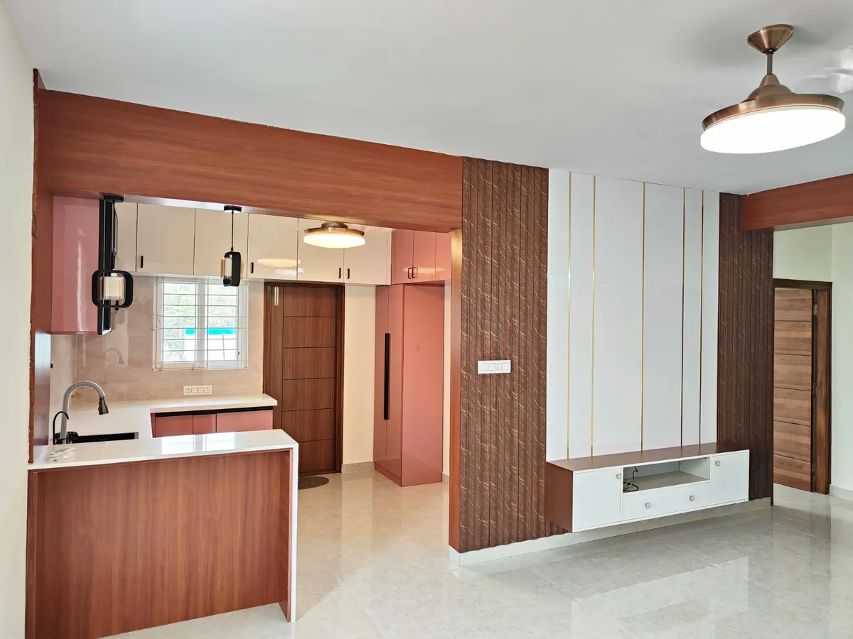 Living room TV wall with vertical gold-striped wood panelling and a floating white TV console, kitchen visible through the archway on the left