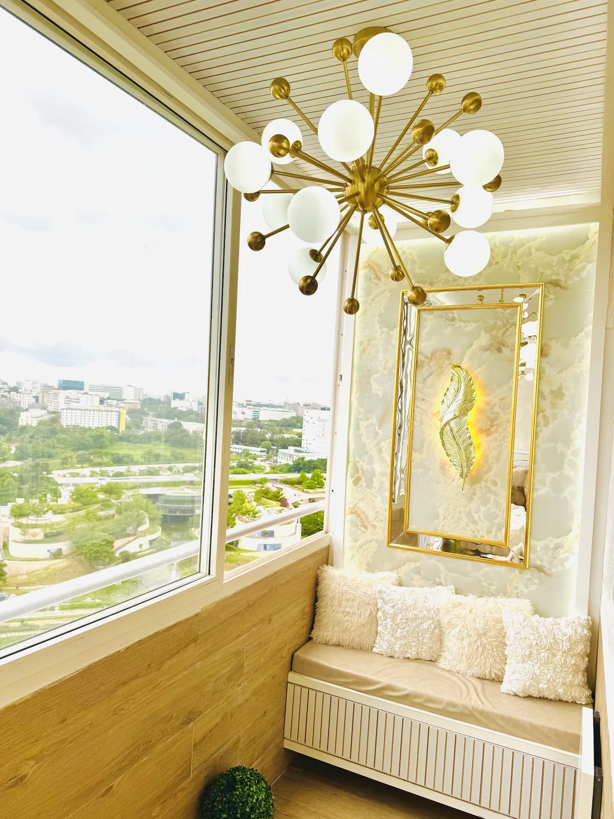 Balcony seating nook with a gold sputnik multi-globe chandelier, an onyx marble feature wall with a mirrored gold leaf art panel