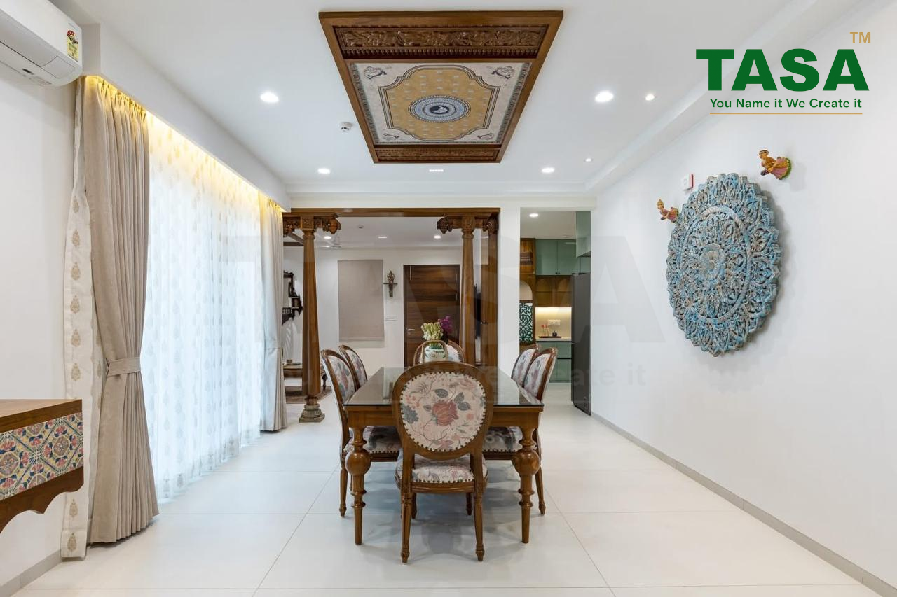 Dining room with a hand-carved wood ceiling medallion above a glass-top wood dining table, ornate carved entrance pillars, sheer curtains