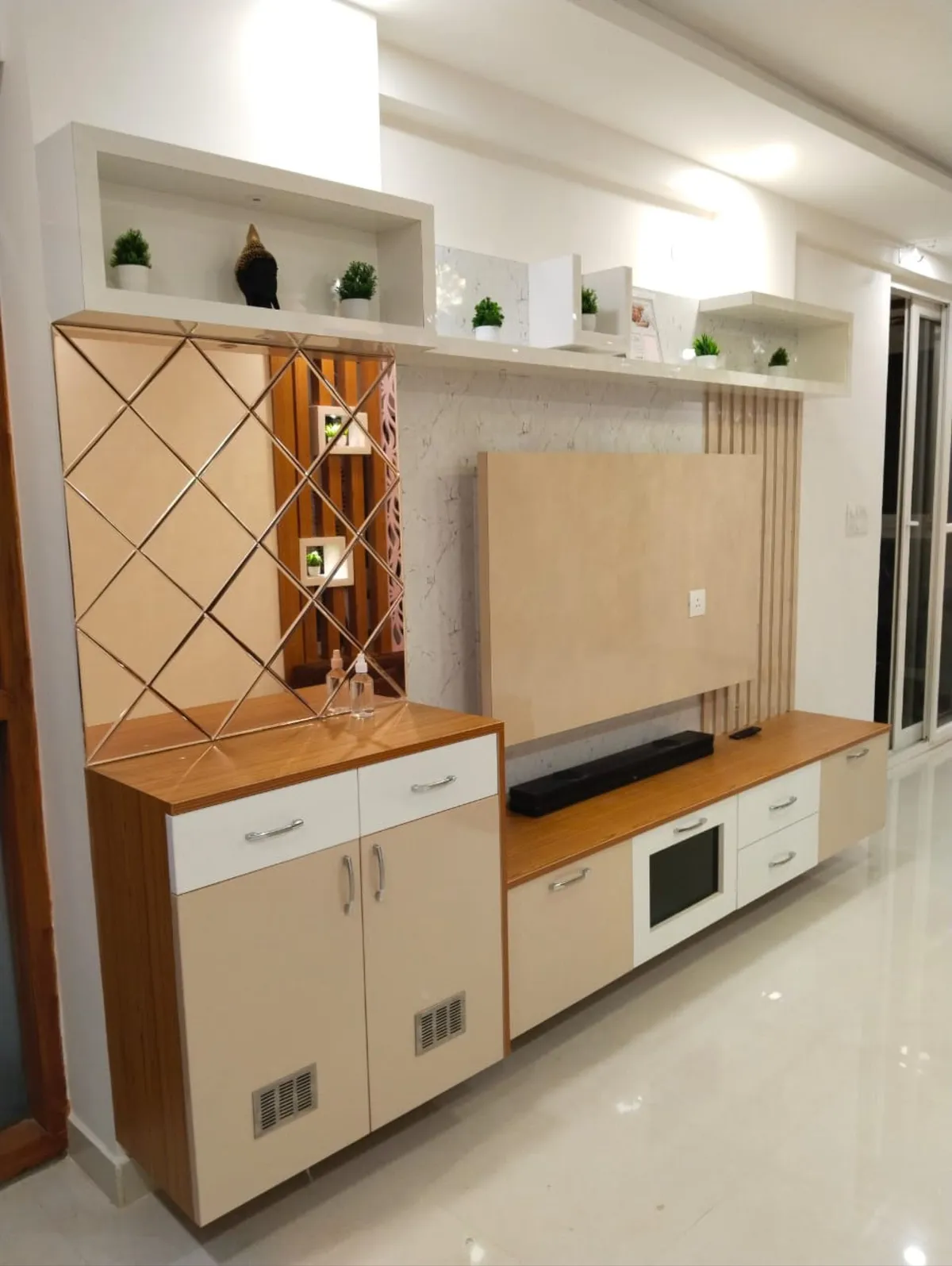 Combined TV unit and shoe cabinet wall with a diamond mirror-panel accent, open display shelves styled with plants and a bird figurine